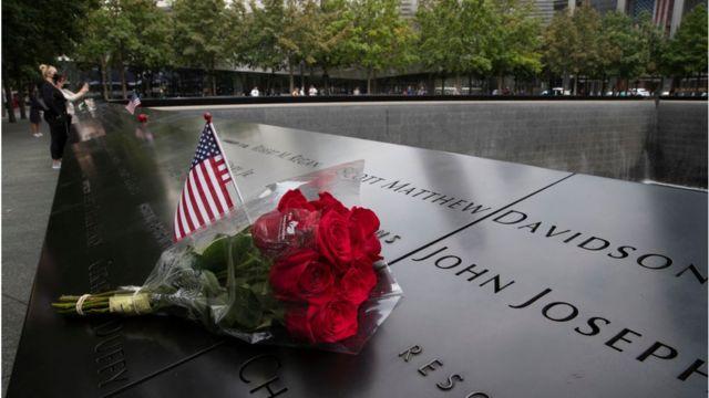 Một lá cờ Mỹ và hoa được đặt gần tên của một nạn nhân tại Đài tưởng niệm vụ 11/9 tại khu Ground Zero hôm 8/9/2021 ở New York, Hoa Kỳ