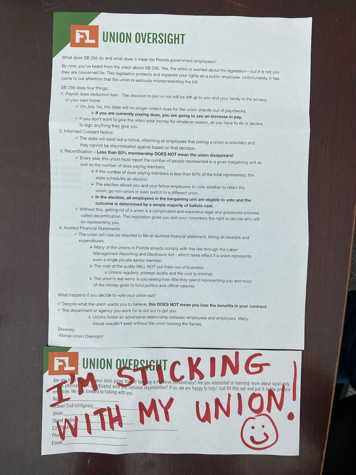 Legal-sized white flier from FL Union Oversight, with green heading, listing provisions of SB 256 and including a detachable form at the bottom for more information. "I'm Sticking With My Union! (smiley face)" is handwritten in red marker.