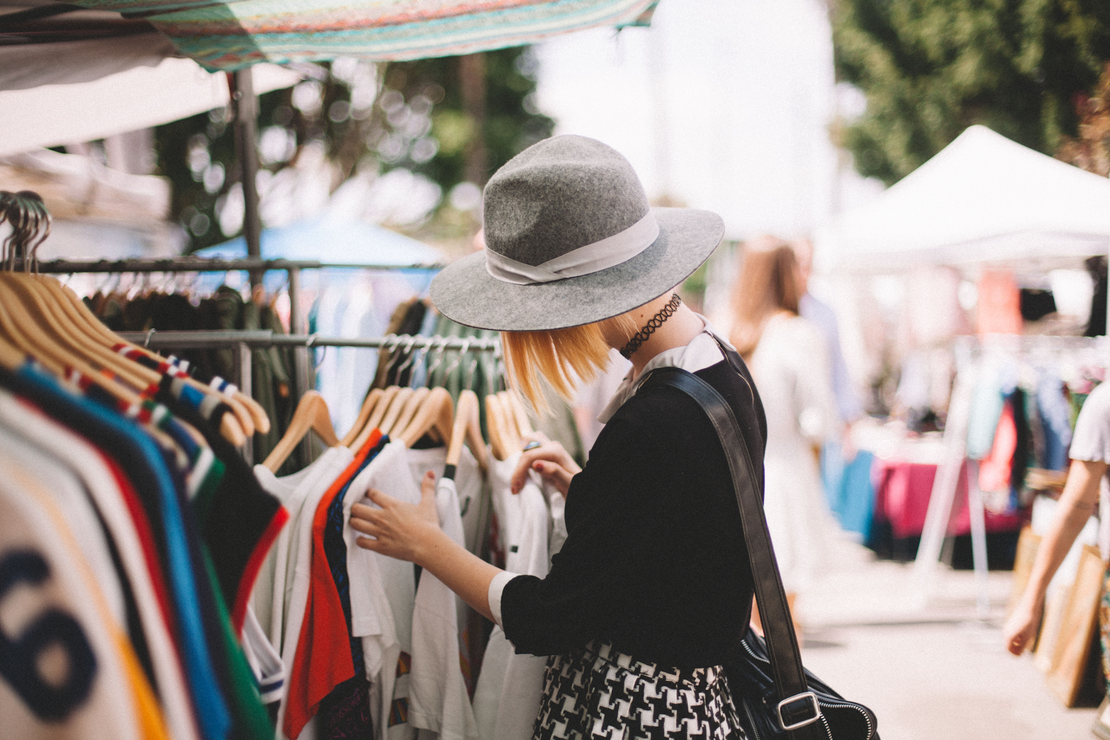 A customer browses a clothing rack at a vintage pop-up shop