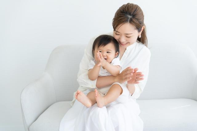 赤ちゃんを抱えて一緒に遊ぶ女性