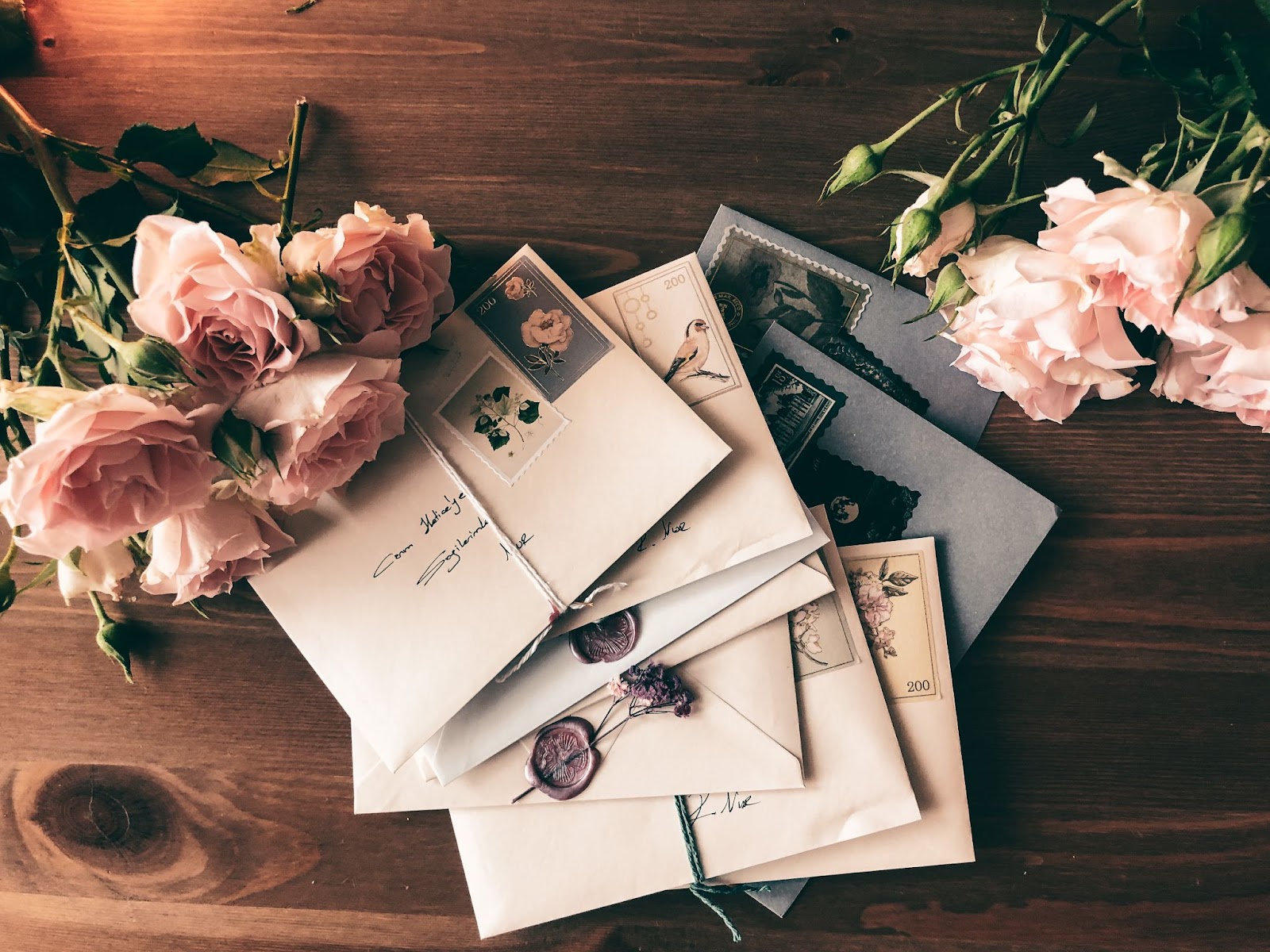 Envelopes tied and stamped  on a table with flowers