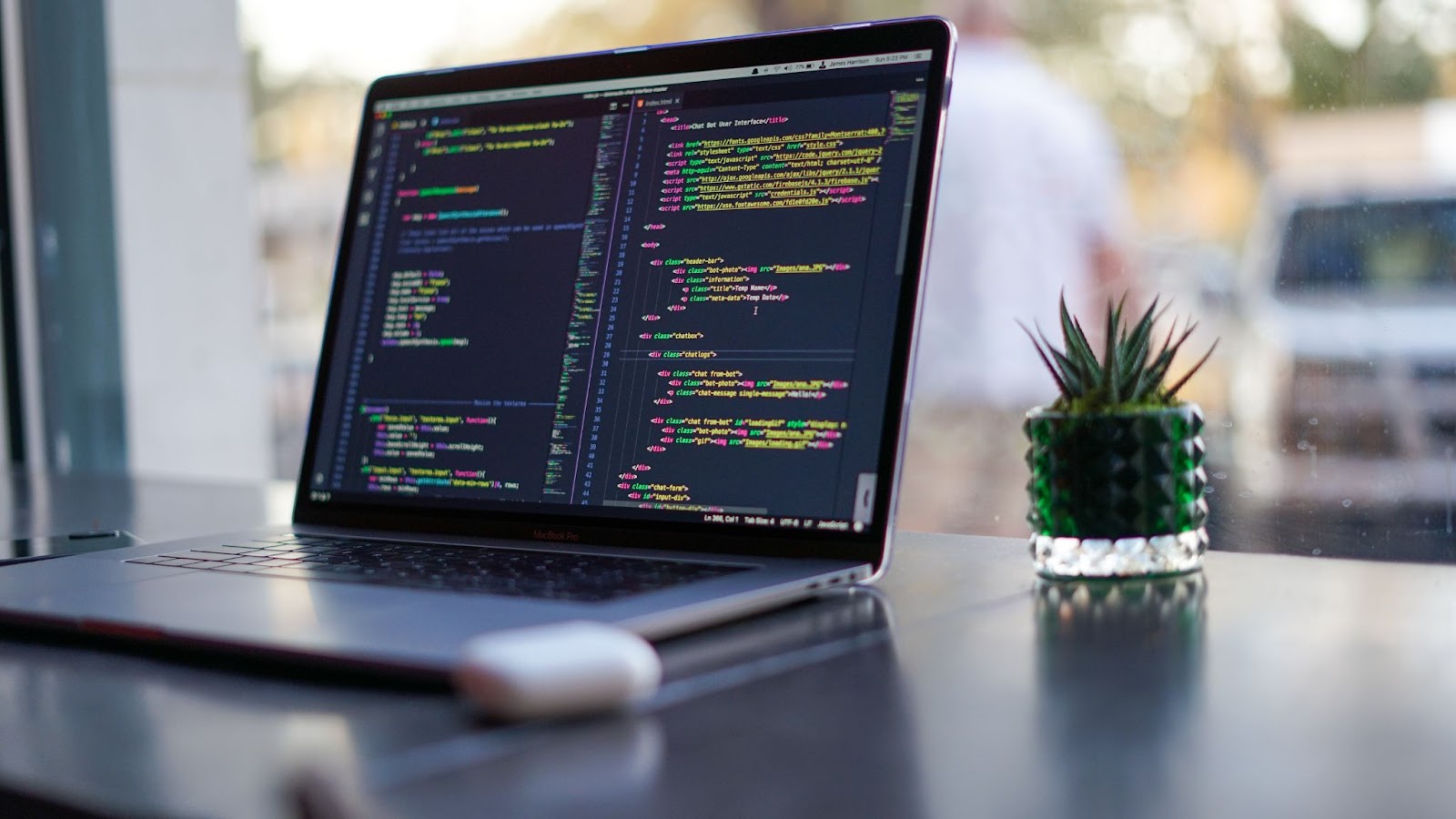 A laptop on a desk with code on its screen.