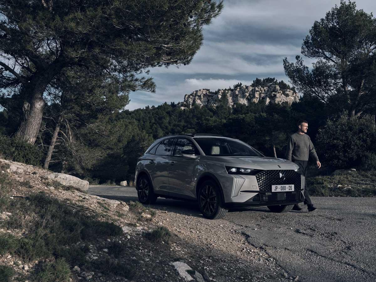 A person standing next to a car

Description automatically generated