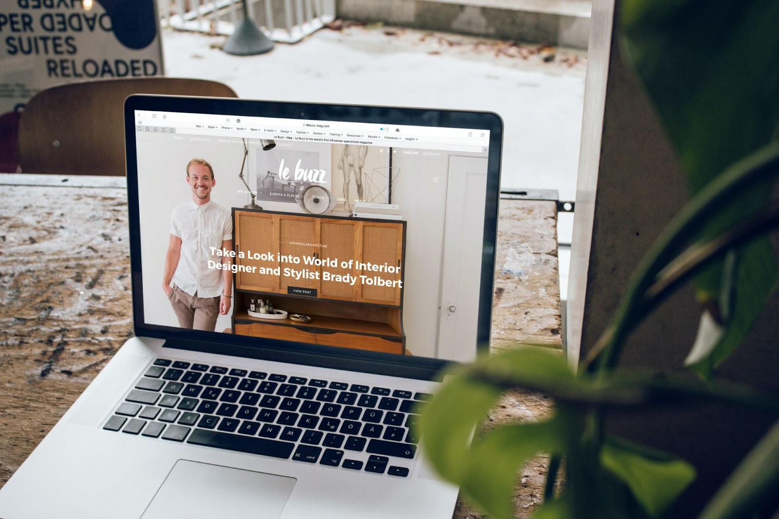 An image of a laptop displaying a clean, simple website for Le Buzz. The word 'the' is missing from the phrase "Take a Look into World of Interior Designer and Stylist Brady Tolbert"