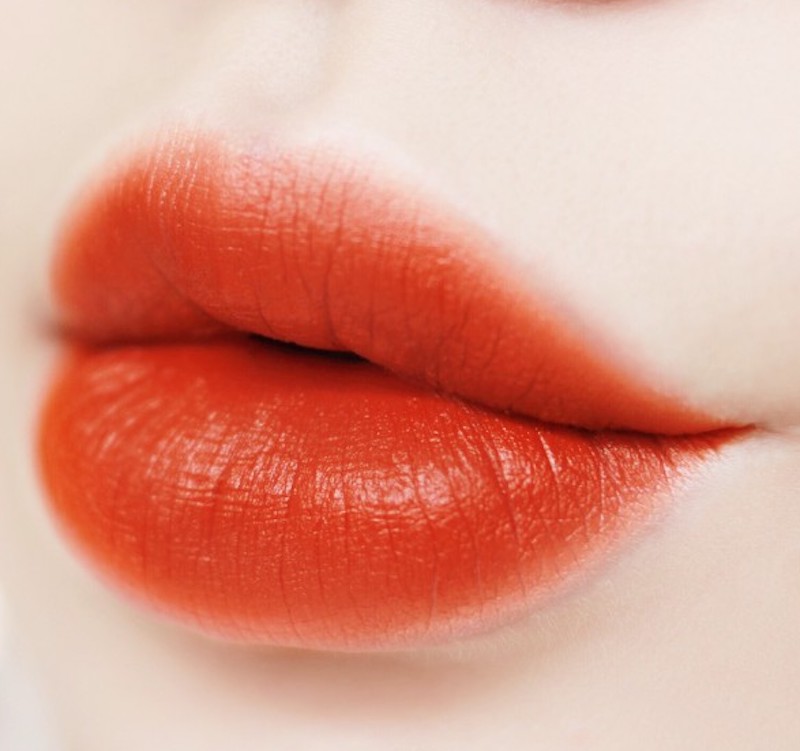 Phun môi màu đỏ cam sử dụng thiết bị phun chuyên dụng, tạo màu môi đỏ cam trên lớp thượng bì của môi.