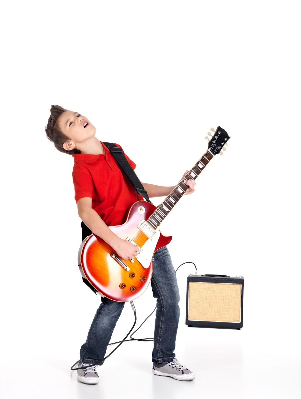 A picture of a young boy playing an electric guitar and rocking out