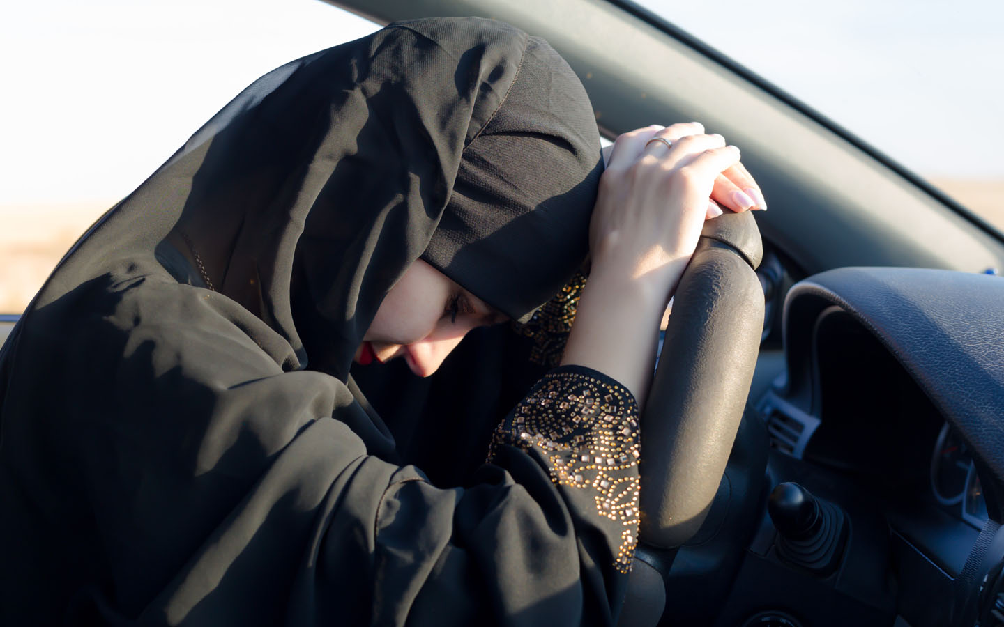 tired woman driver with head on car's steering. the condition may lead to highway hypnosis
