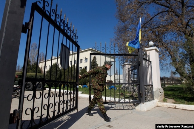 Украинский военнослужащий закрывает ворота на украинской военной базе в Бельбеке (2014 год)