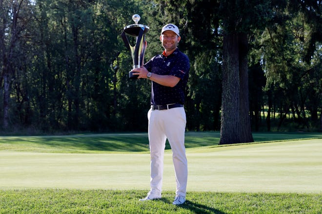 Branden Grace lifts his trophy after winning the LIV Golf tournament at Pumpkin Ridge Golf Club.