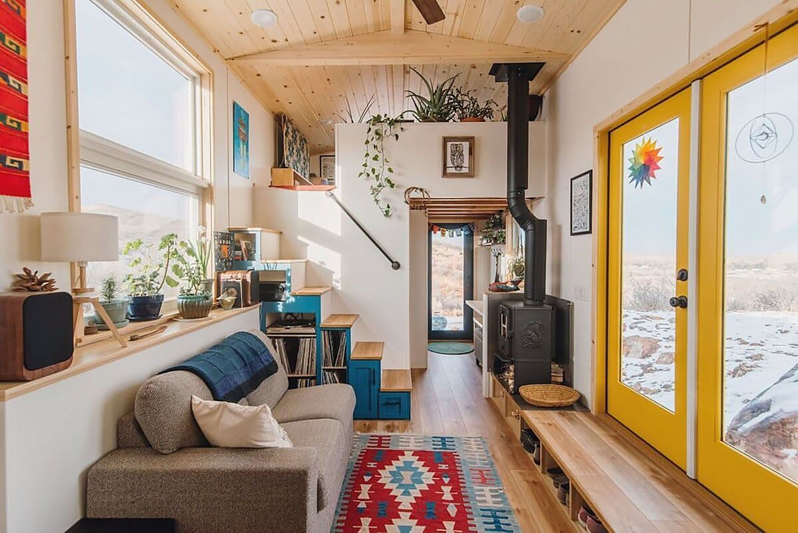An extra wide tiny house with lots of storage and a fireplace