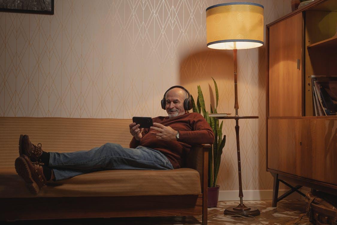 Free Photo of an Elderly Man with Black Headphones Watching on His Phone Stock Photo