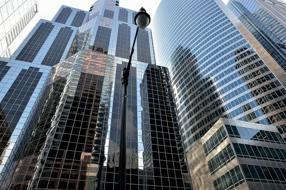 In the foreground, a black lamppost. In the background, towering skyscrapers.