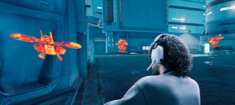 Man wearing INZONE H9 headset in a game scene showing buildings and hidden targets highlighted in orange