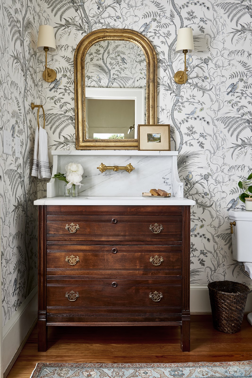 Dark wood vanity and gold mirror 