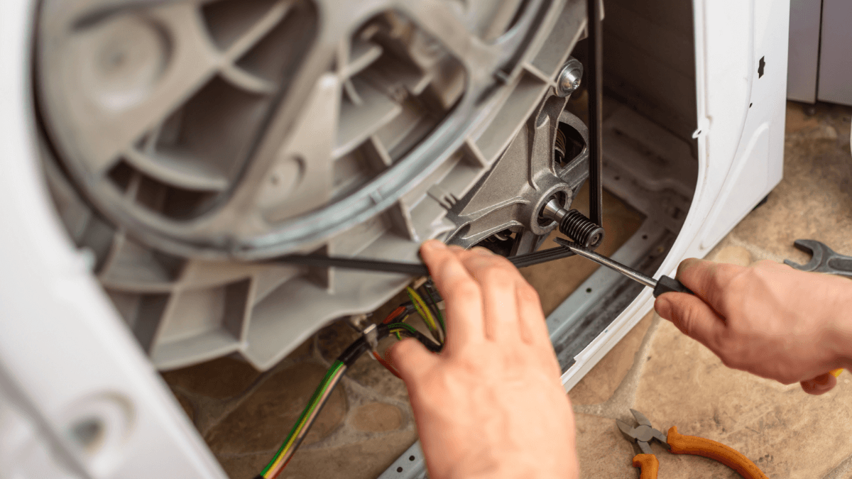 Técnico fazendo manutenção em lavadora