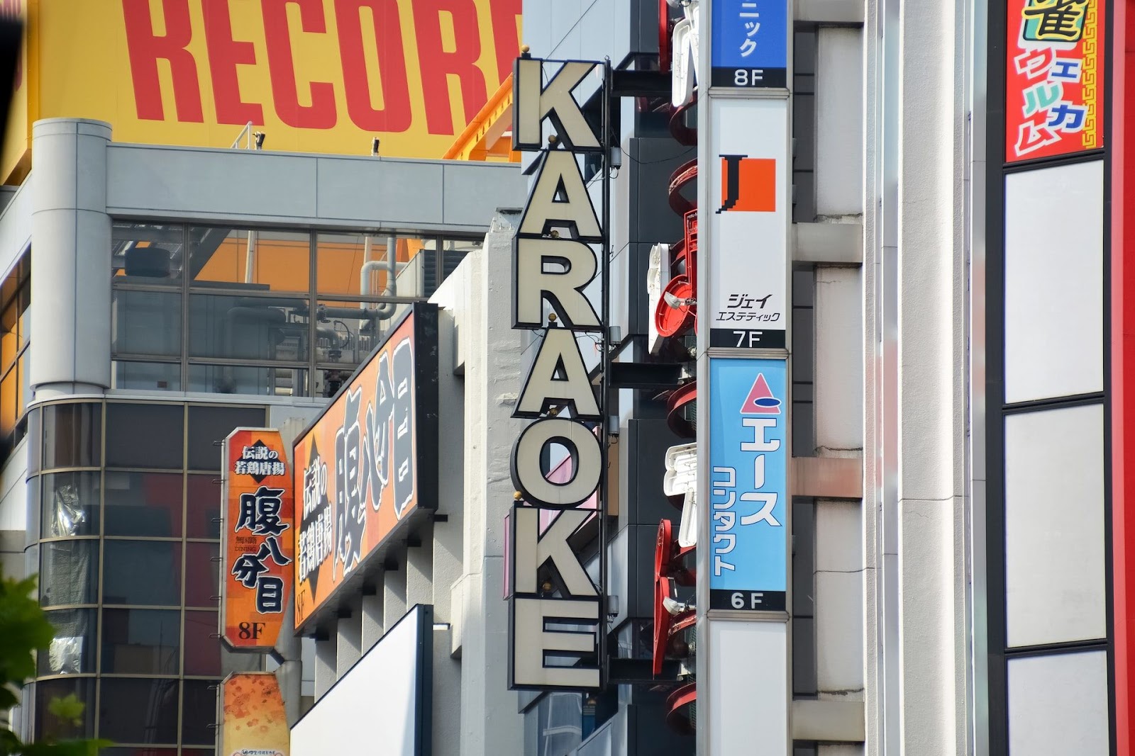 Kyltti karaokebaarista rakennuksen kyljessä japanilaisella kadulla.