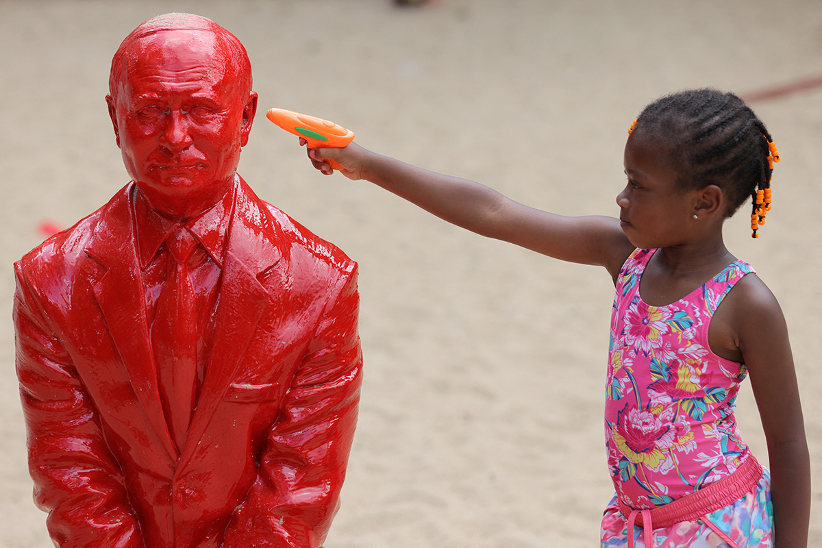 Девочка приставила игрушечный пистолет в голове скульптуры Владимира Путина, Нью-Йорк, 2 августа 2022 года. Фото: Reuters