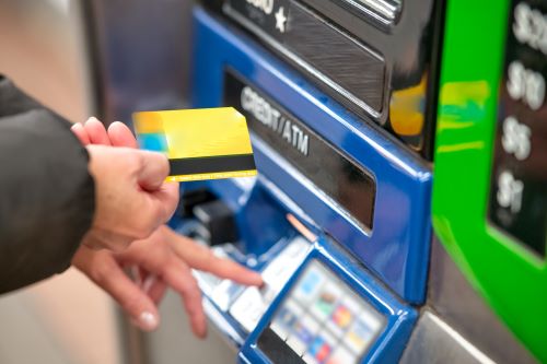 Person at an ATM getting a credit card cash advance after determining it is one of the best ways to borrow money. 