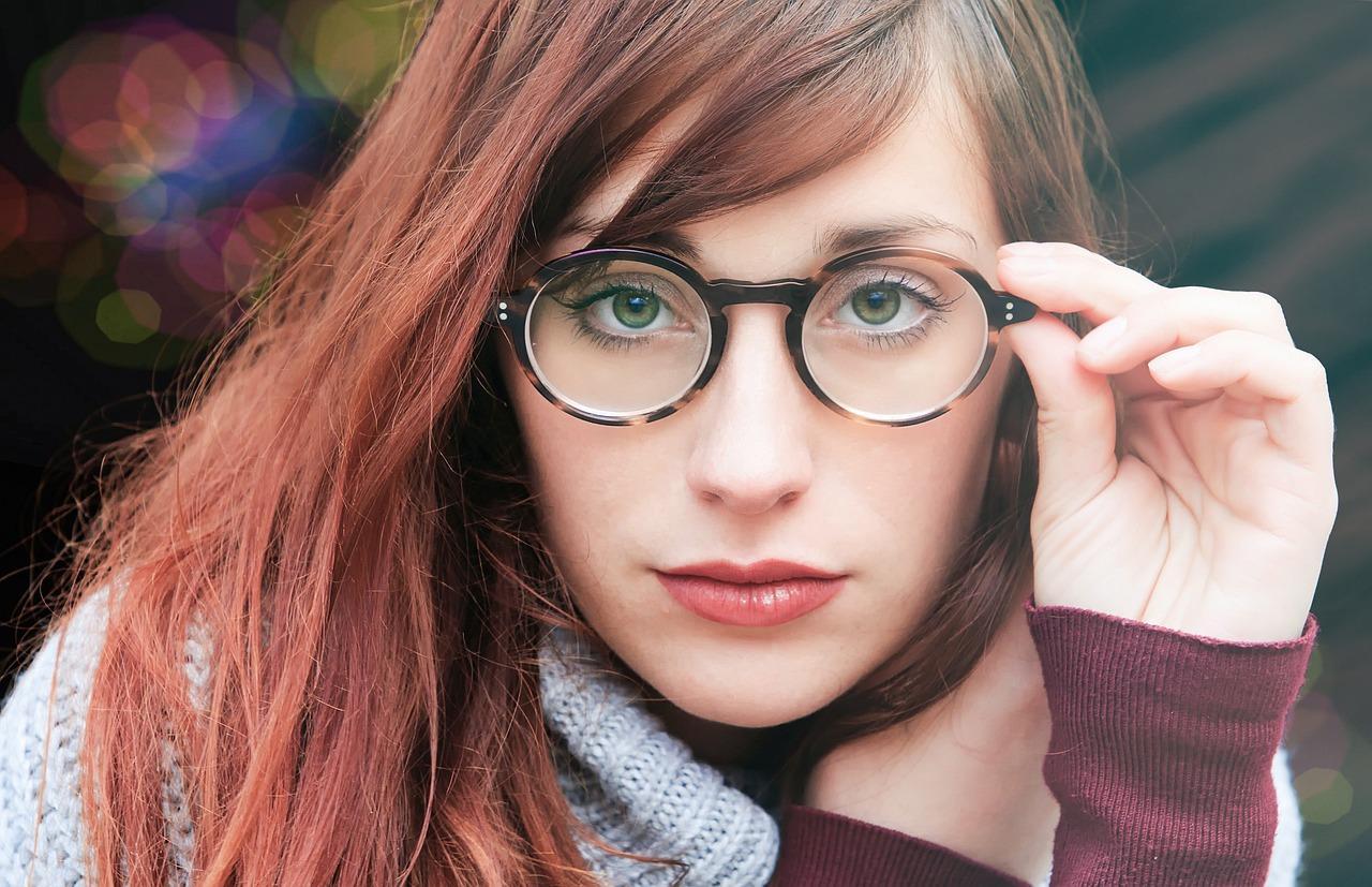 A person with red hair wearing glasses Description automatically generated