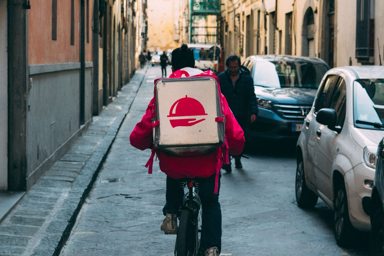 Delivery man from an online food delivery service provider cruising the street to complete their orders on time.