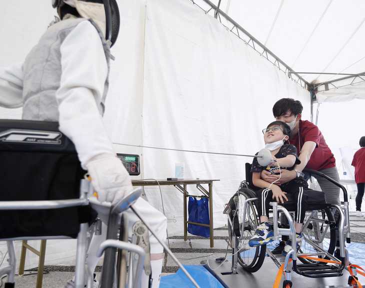 駒沢オリンピック公園で開かれたイベントで、車いすフェンシングを体験する谷本優翔さん＝２０日午前、東京都世田谷区