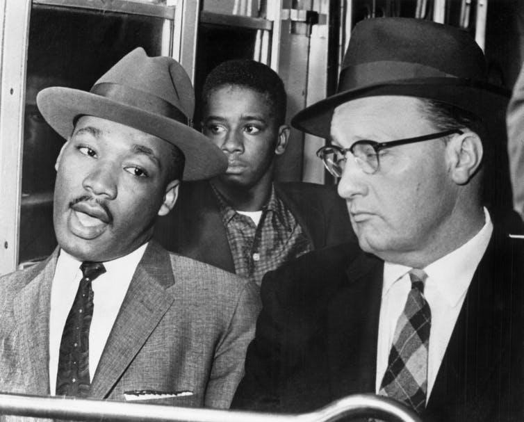 Martin Luther King Jr. riding in the front of a bus.