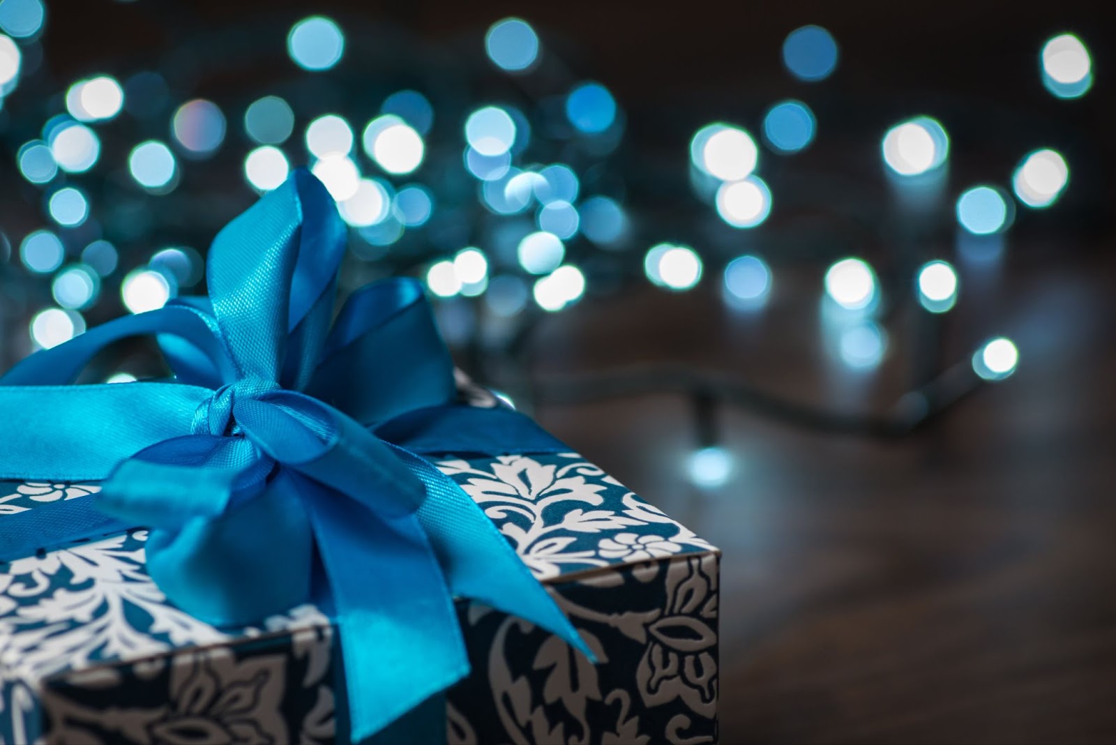 Blue Christmas lights with box gift wrapped in a bow