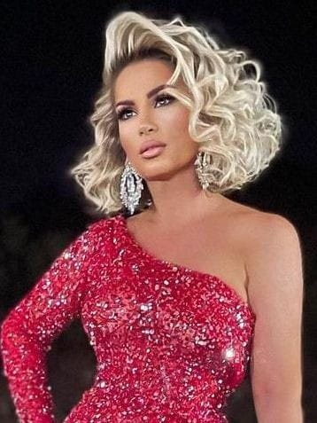 a beautiful lady wearing blonde wavy short hair with cute earrings and a red sequin dress