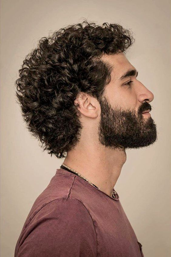 Man looking sideways wearing curly men's hairstyle
