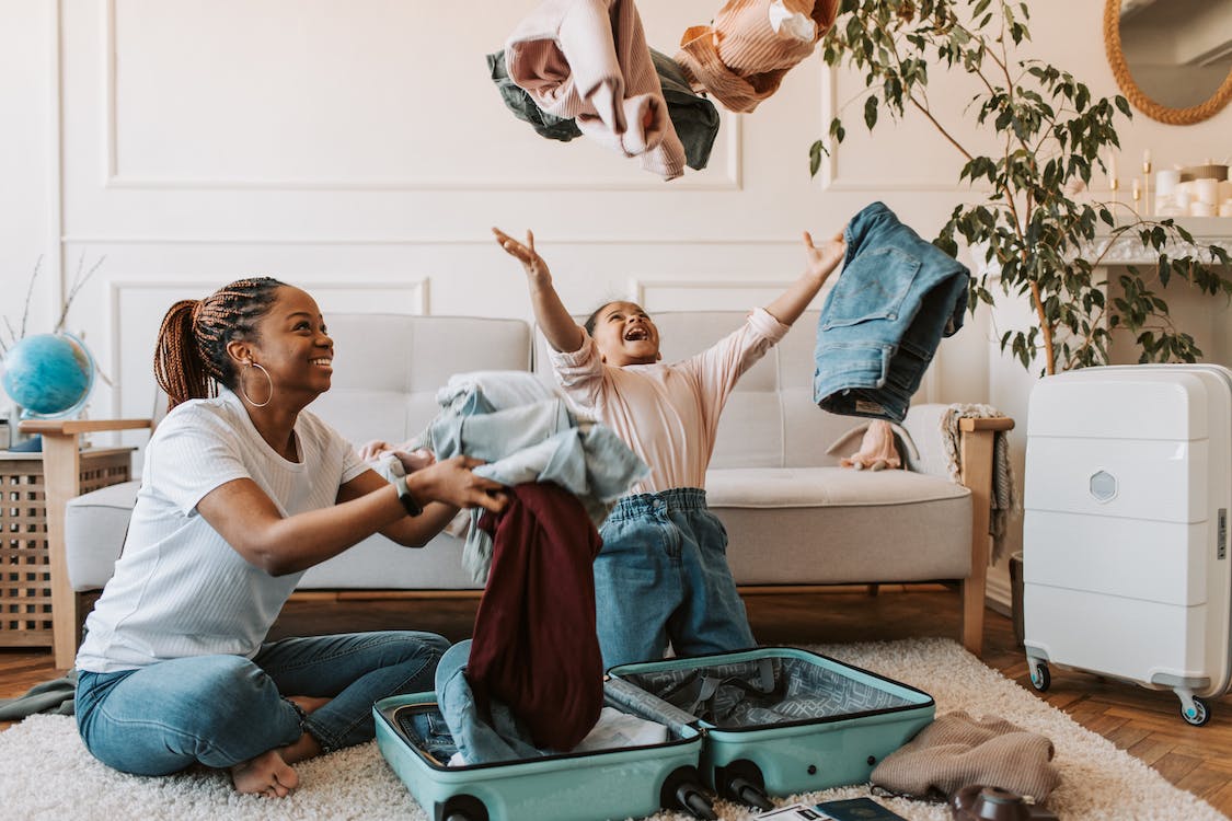 happy mother and daughter packing a suitcase