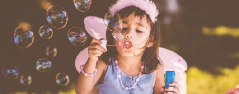 Girl blowing bubbles for kids birthday party wishes