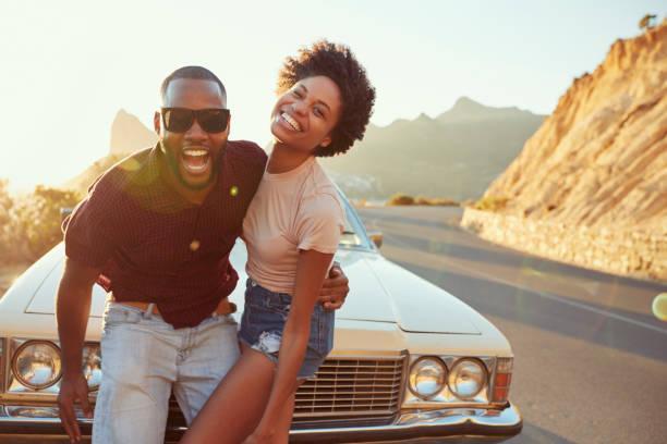 Portrait Of Young Couple Standing Next To Classic Car Portrait Of Young Couple Standing Next To Classic Car couples on a trip stock pictures, royalty-free photos & images