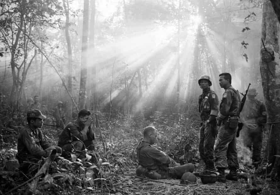 South Vietnamese troops and their US advisers resting in the jungle near the town of Binh Gia, 40 miles east of Saigon, in January 1965.