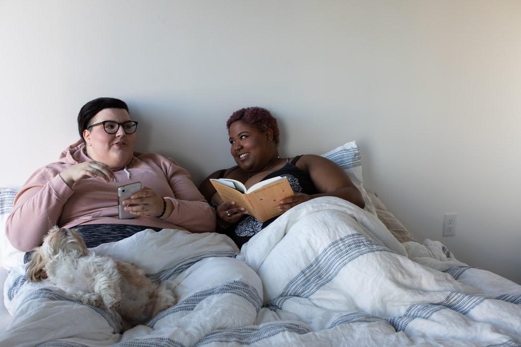 Two people on a bed with a dog

Description automatically generated with medium confidence