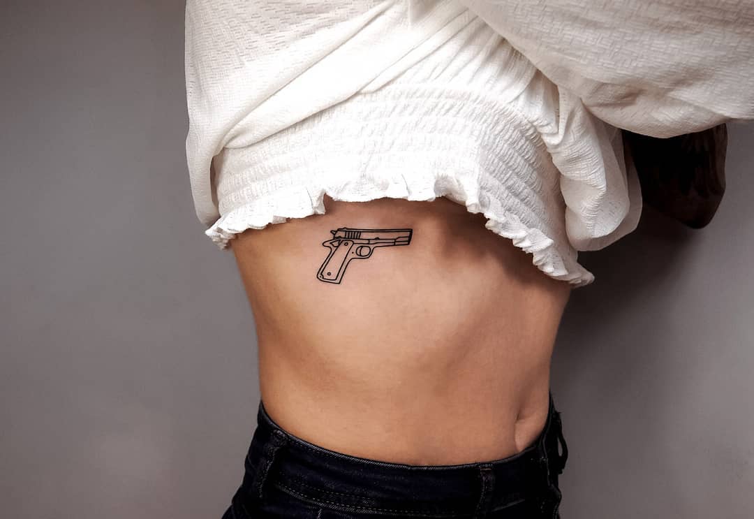 Small Gun Tattoo Design On Women Waist