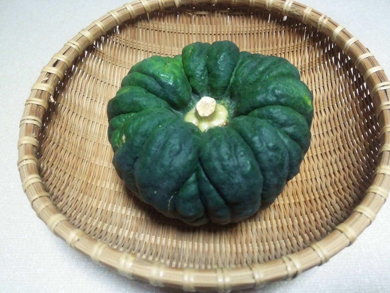 円形のざるに乗った典型的な形のカボチャの画像です。