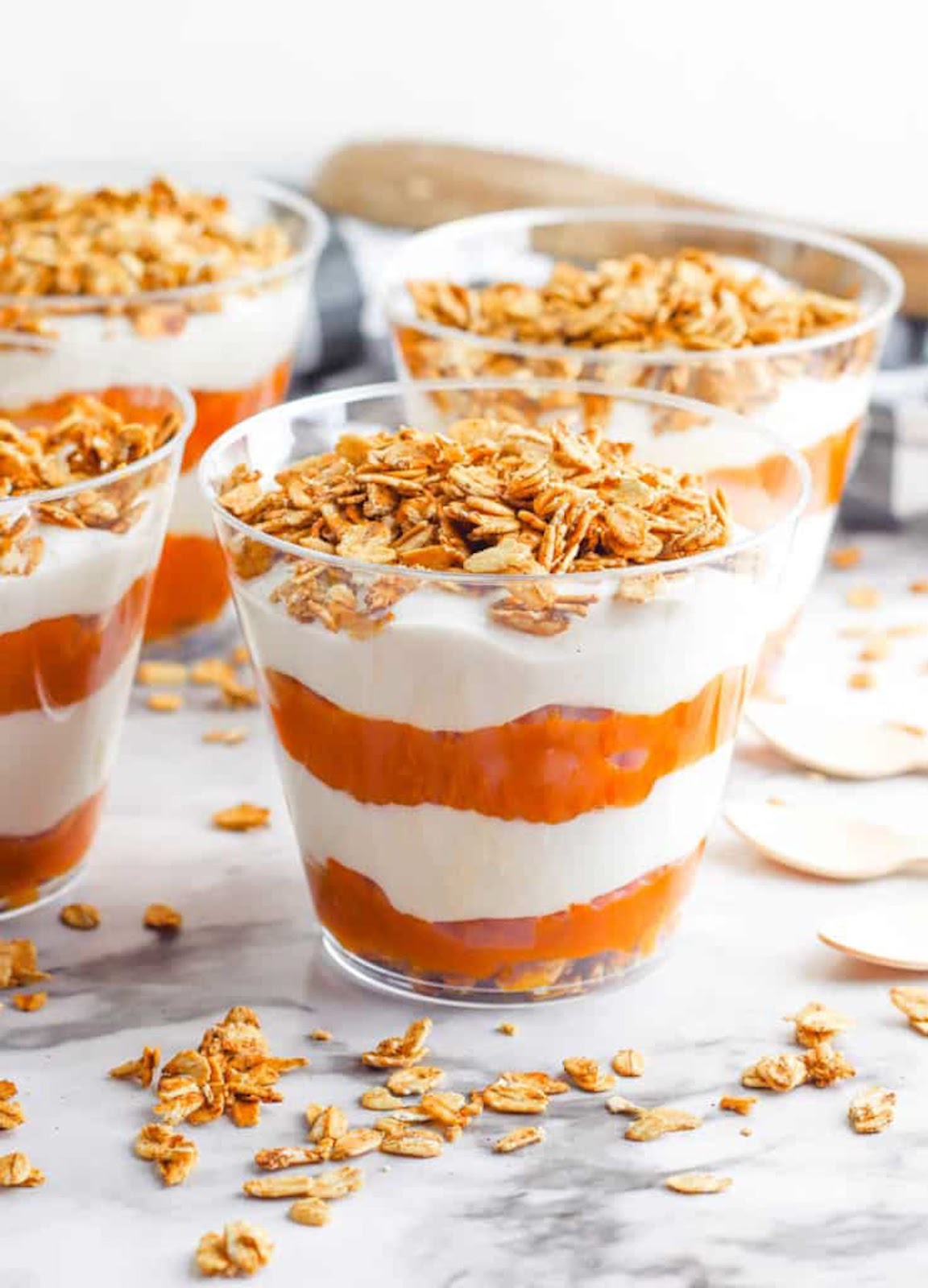 Pumpkin parfaits with spiced granola served in glass cups.