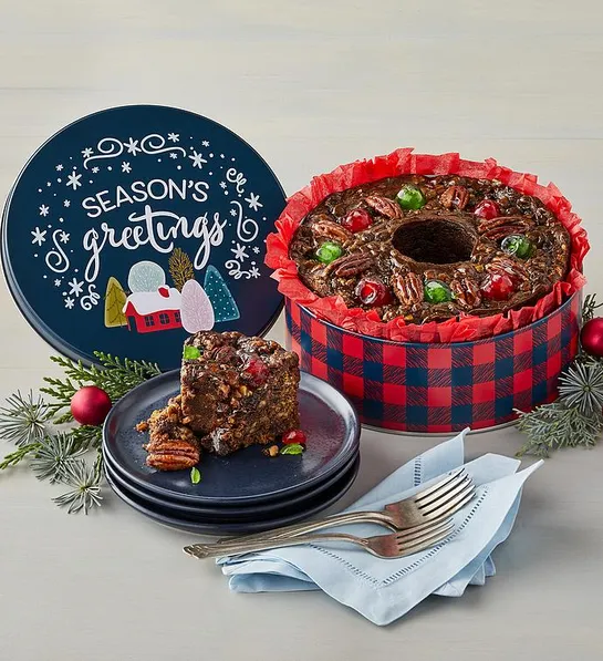 fruitcake inside a blue holiday tin that reads seasons greetings