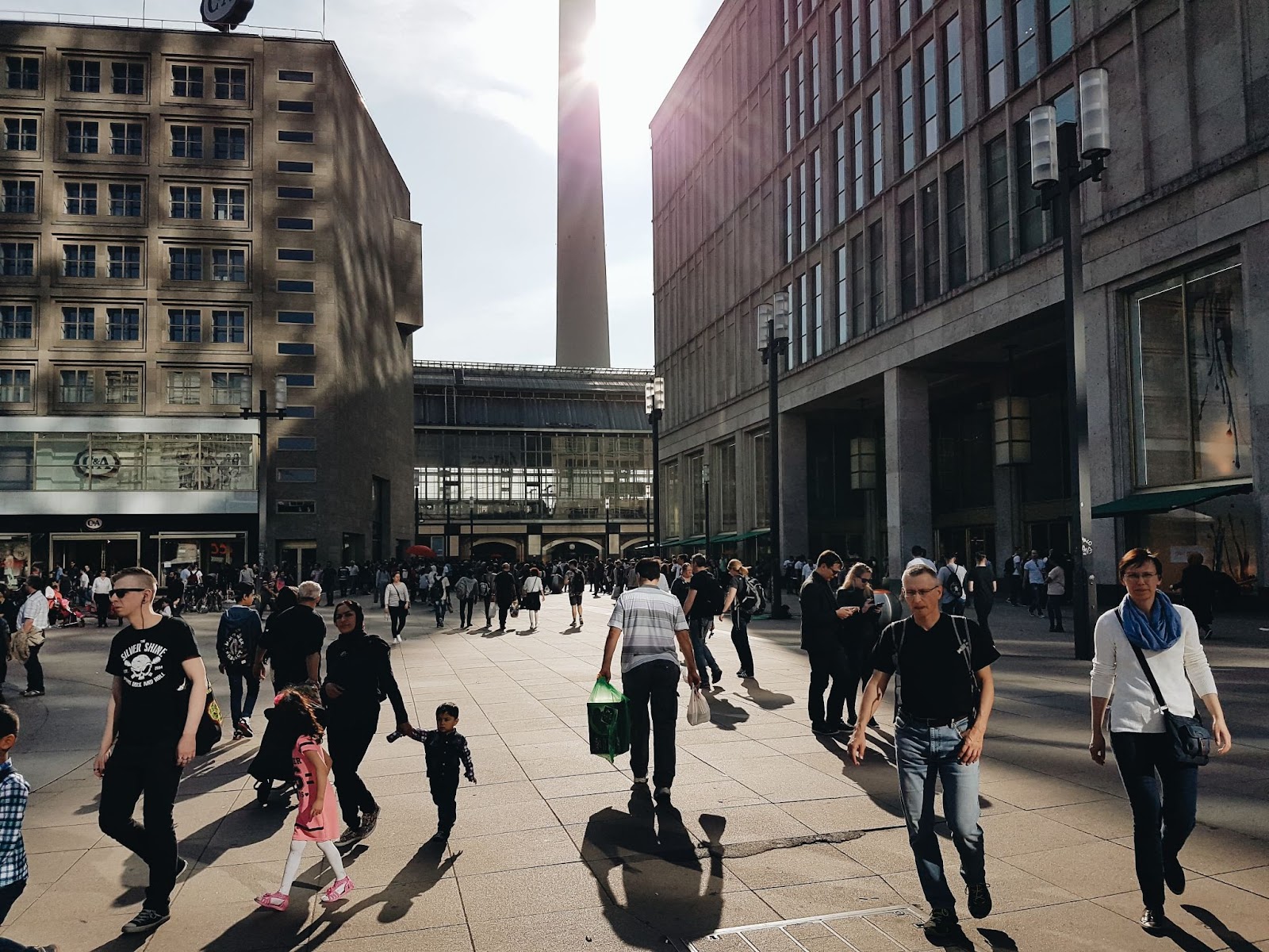 Many people walking along a crowded street.