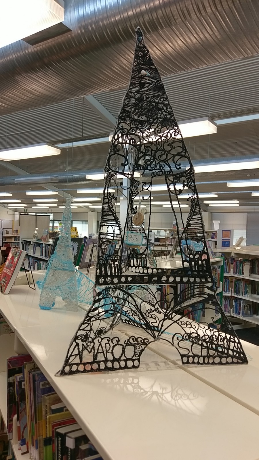 Photograph of library shelves and student work on display.