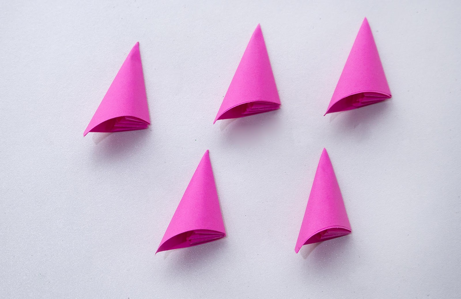 Five origami flower petals in conical shape made from pink paper