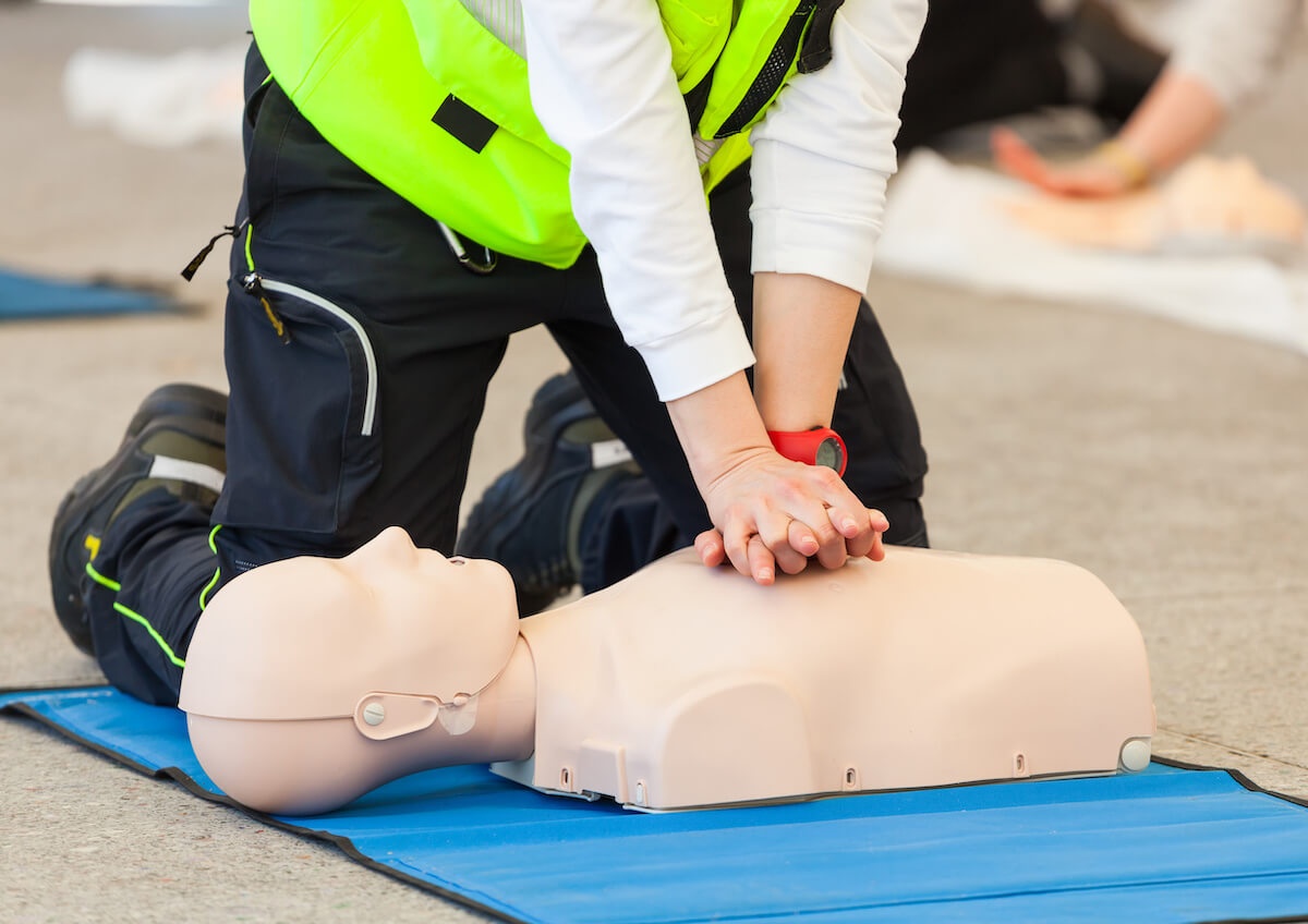 Person demonstrating CPR on a dummy as part of their safety training