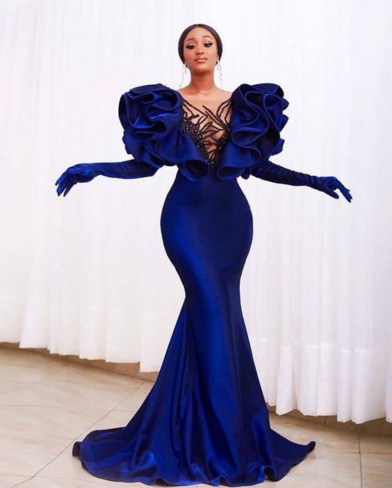 lady posing in a blue mermaid dress with matching lady gloves