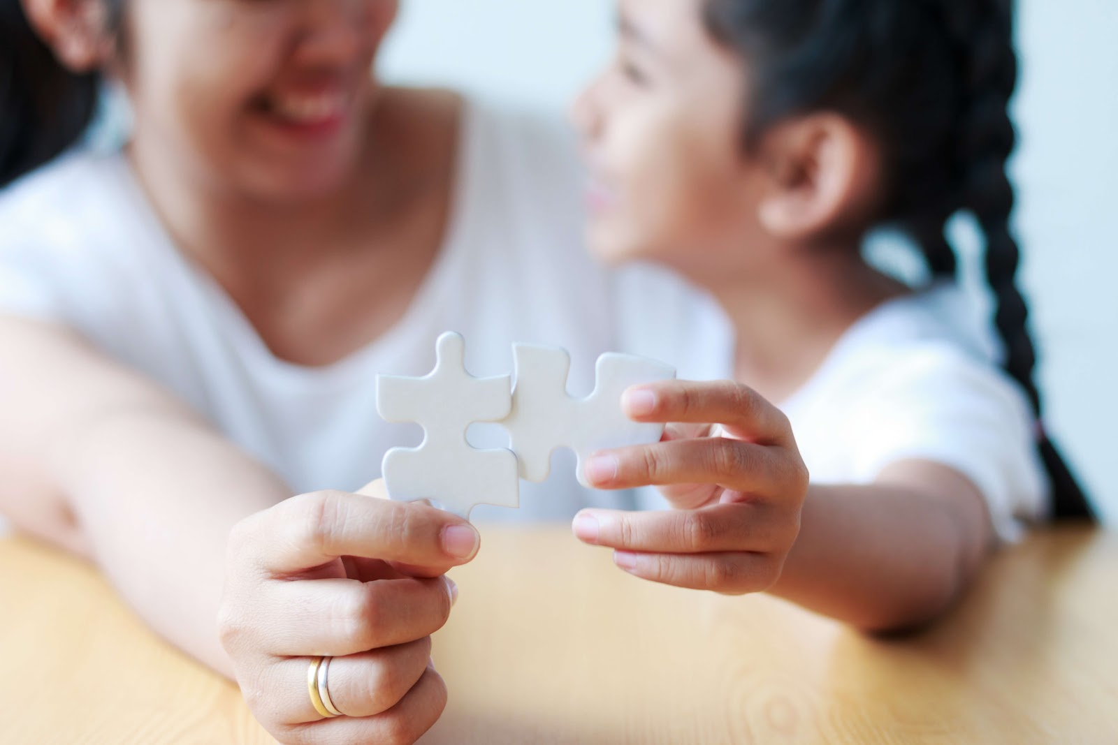 A parent and child holding two puzzle pieces that don't fit together