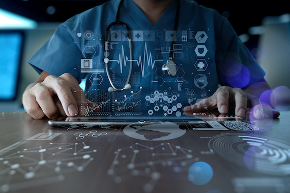 Medical worker touching iPad screen with hovering digital charts