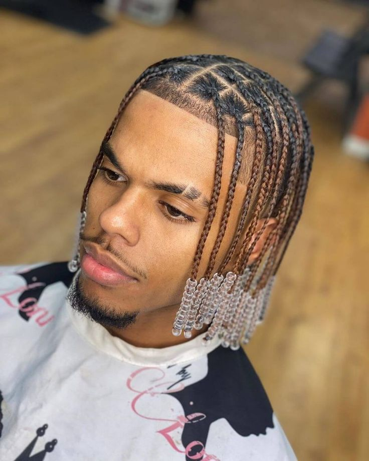 a guy wearing box braids with beads