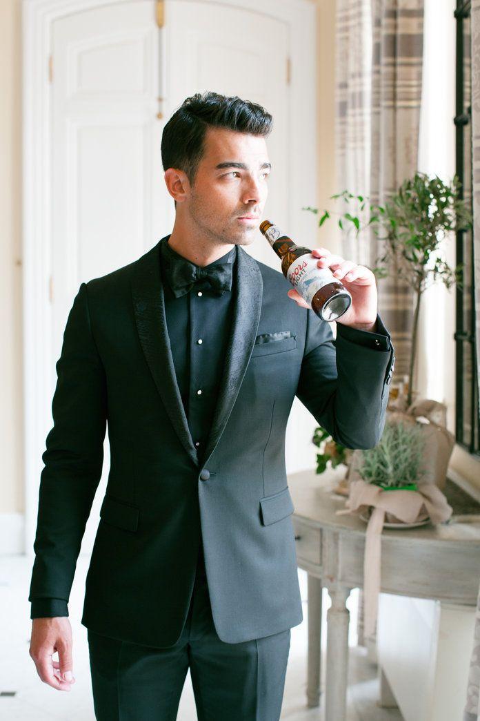 A person in a suit drinking from a bottle  Description automatically generated with medium confidence