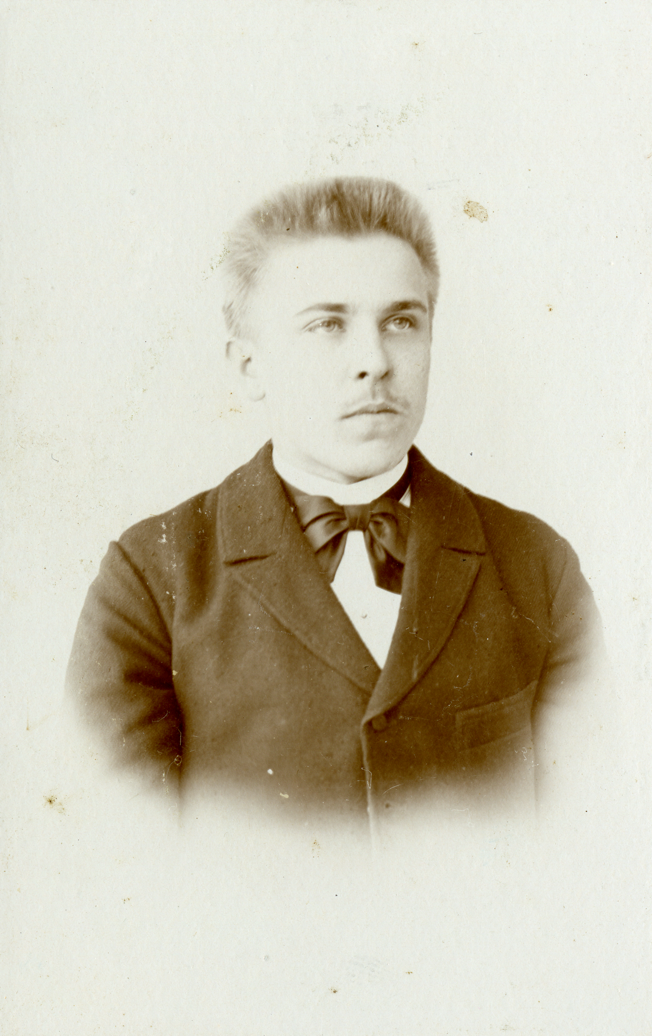 A vintage photo of a person wearing a suit and tieDescription automatically generated