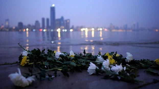 图为，2020年4月3日，湖北武汉市清明节前夕，传统的丧葬花是菊花，放在长江两岸祭奠因武汉肺炎死去的人们。（路透社）