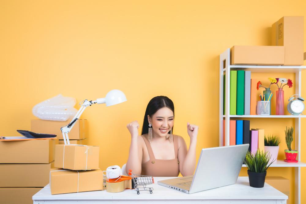 A person sitting at a table with a computer and a lampDescription automatically generated with low confidence